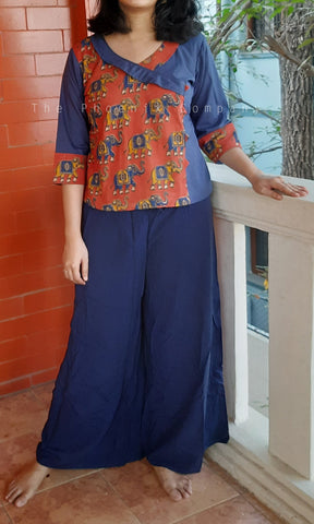 Person wearing a colorful top and blue pants.