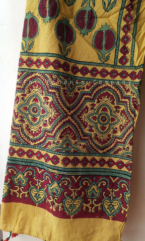 Yellow fabric with intricate red, green, and gold patterns